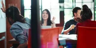 慢动作集团亚洲人公司员工和经理在办公室会议室开会。手握纸抛出表达喜悦的微笑和幸福的笑声