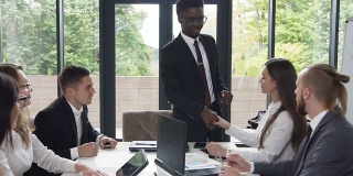 一个成功的非洲裔美国商人和白人同事在办公室的会议室里，一个黑人在和同事开会时握手。多莉拍摄