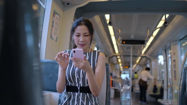 年轻女子在乘坐地铁上下班时使用手机