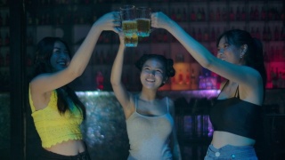 一群年轻的亚洲女人跳舞的朋友享受夜晚的派对。视频素材模板下载