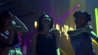 一群年轻美丽的亚洲女子在夜总会喝酒，随着dj的音乐跳舞。漂亮的女朋友享受夜生活，在迪斯科舞会上一起疯狂跳舞视频素材模板下载