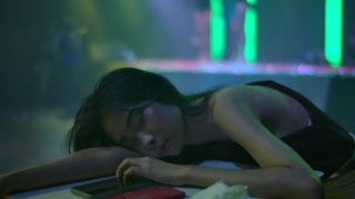 晚上酒吧里睡在桌子上的醉酒女人。视频素材模板下载