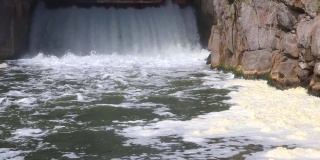 流动的水和水从一个小水坝开着的闸门喷射出来