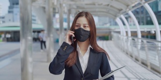 年轻的女商人在办公室外工作时要戴上防护口罩