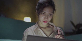 亚洲商界女性在新常态下保持社交距离以防病毒，在家里打开笔记本电脑查看电子邮件或客户订单。