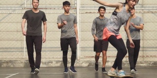 五个年轻的亚洲成年人在户外篮球场上玩耍