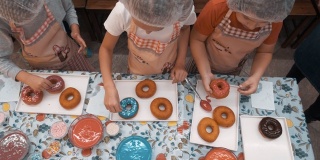 俯瞰孩子们在美味的甜甜圈上
