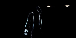 一个穿着LED西装的人在黑暗中跳舞