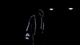一个穿着LED西装的人在黑暗中跳舞视频素材模板下载
