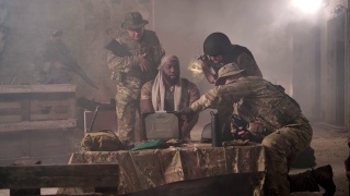 一小队士兵在黑烟基地用笔记本电脑工作视频素材模板下载