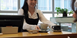 年轻女性顾客为咖啡饮料进行移动支付