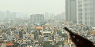 男子拨通电话，窗外是城市的背景