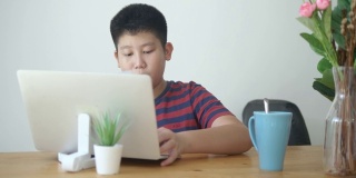 亚洲男孩拿起饭碗为他的家人摆好餐桌，生活方式的概念。