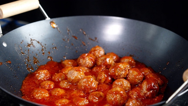 Cooking meatballs in a frying pan. A slow rotation.