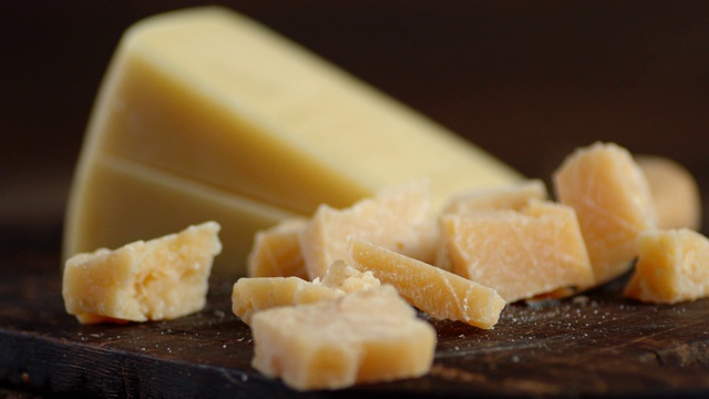一片片的帕尔马干酪落在砧板上。