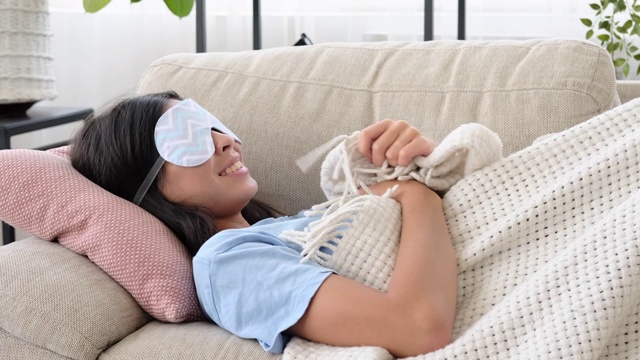 一个女人戴着眼罩睡在沙发上