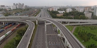 日落时分俯瞰莫斯科多层次交通交汇处上空的航班。城市高速公路上的汽车交通。无人机拍摄的城市景观