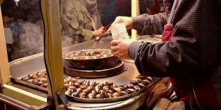 在土耳其的伊斯坦布尔，一名身份不明的土耳其男子在出售带烟的甜栗子。