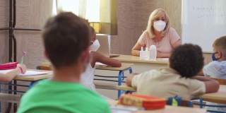 新冠肺炎疫情期间，女教师和学生在教室佩戴防护口罩