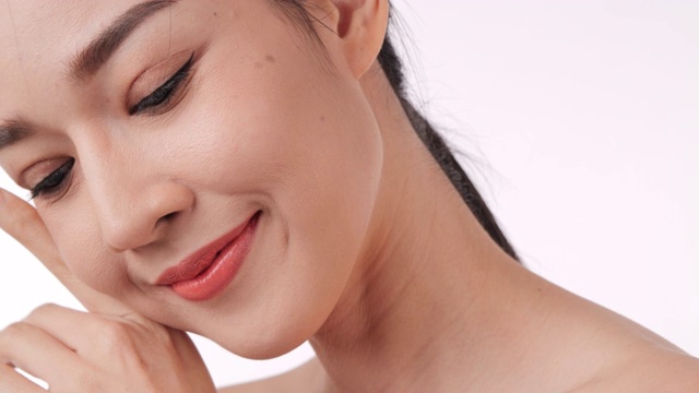 美丽的年轻亚洲女人触摸脸和健康的皮肤的特写。