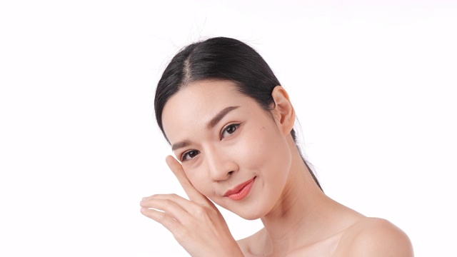 美丽的年轻亚洲女人的肖像触摸脸和健康的皮肤。