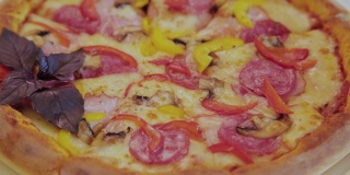 新鲜的热披萨配上香肠和奶酪放在白色的盘子里
