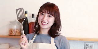 年轻的亚洲女人对烹饪有动力