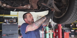 修理工——汽车修理工，白人白人，手上有纹身，在汽车修理店工作，修理电梯上的汽车悬架。