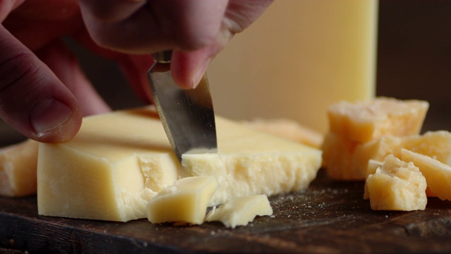 男性用刀切帕尔玛干酪块。