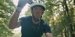 SLO MO休闲骑行者在骑自行车穿过森林时喝酒