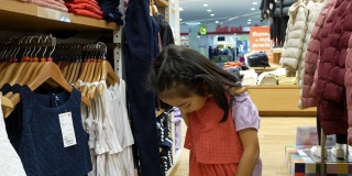 一个女孩穿着紫色的t恤在精品店购物