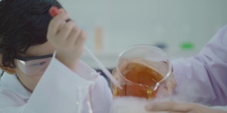 亚洲的孩子在科学实验室里学习，在实验中玩得很开心。使用干冰与水混合产生冷却蒸汽
