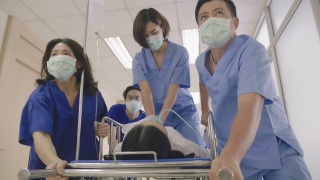 亚洲医疗队将心脏骤停的病人放在担架上进行心肺复苏视频素材模板下载
