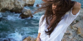 美丽的年轻女子，海风吹拂着她的头发
