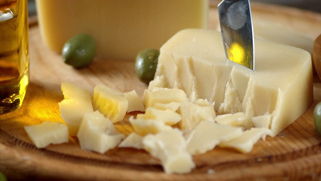 将帕尔玛干酪切成薄片，放在木砧板上，慢慢旋转。