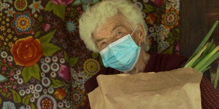 真实人物老年妇女戴口罩以避免传染病。看着相机微笑