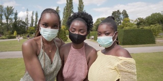 三个年轻女子一起戴着口罩