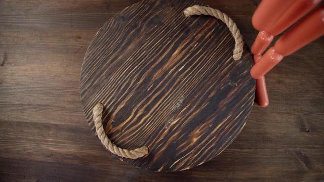 落在煮香肠的木托盘上。