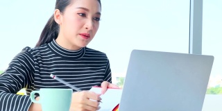 年轻的亚洲女商人用笔记本电脑向同事展示新的战略商业计划