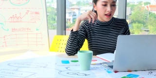 年轻的亚洲女商人用笔记本电脑向同事展示新的战略商业计划