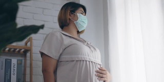 亚洲孕妇戴防护口罩以防止细菌。居家隔离，预防冠状病毒和新冠病毒感染。4 k慢动作