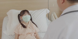 医生在病房探望一个小女孩的康复病人。