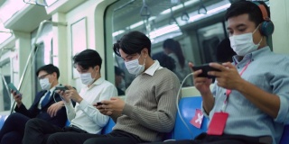 年轻男子在地铁安全行驶时使用手机保持社交距离