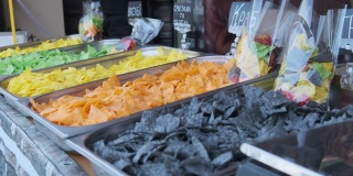 街头美食展示上的彩色薯片。节日上的街头快餐