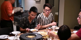 亚洲华人家庭和朋友在家里吃着传统的中国汽船菜共进晚餐