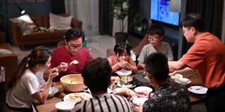亚洲华人家庭和朋友在家里吃着传统的中国汽船菜共进晚餐