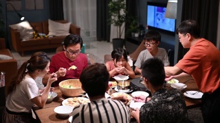 亚洲华人家庭和朋友在家里吃着传统的中国汽船菜共进晚餐视频素材模板下载