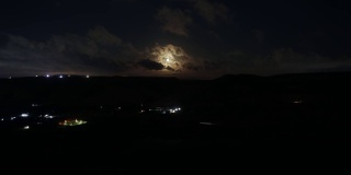 山岗上的满月夜晚时光流逝。月亮随云移动