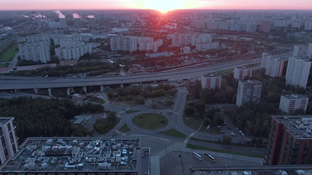 鸟瞰图飞行在一个多层次的交换在大城市。清晨日出时的城市全景