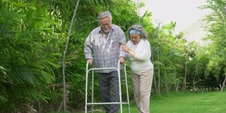 亚洲老夫妇与沃克在家里散步。一位老人和一位老妇人一起在公园里散步。成熟的丈夫和妻子共同支持花园